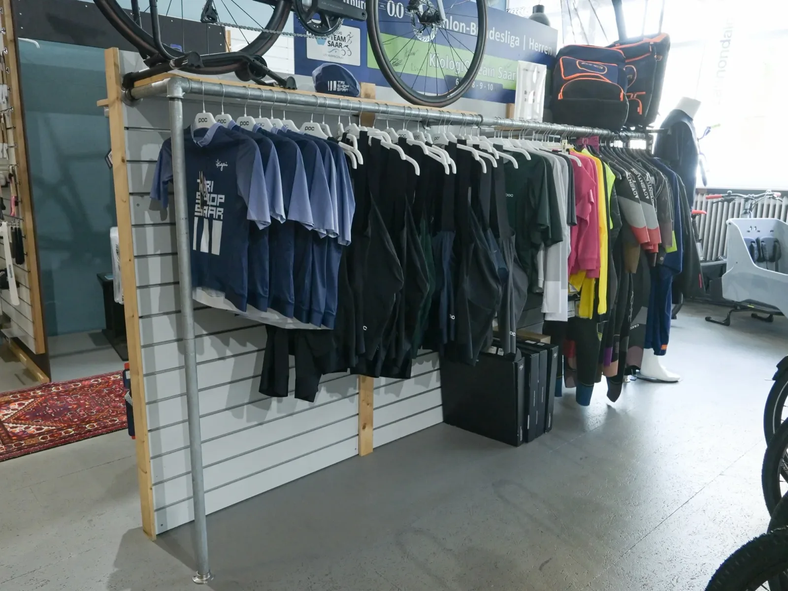 Bekleidungswand im Zubehörbereich von Tri Shop Saar in Saarbrücken
